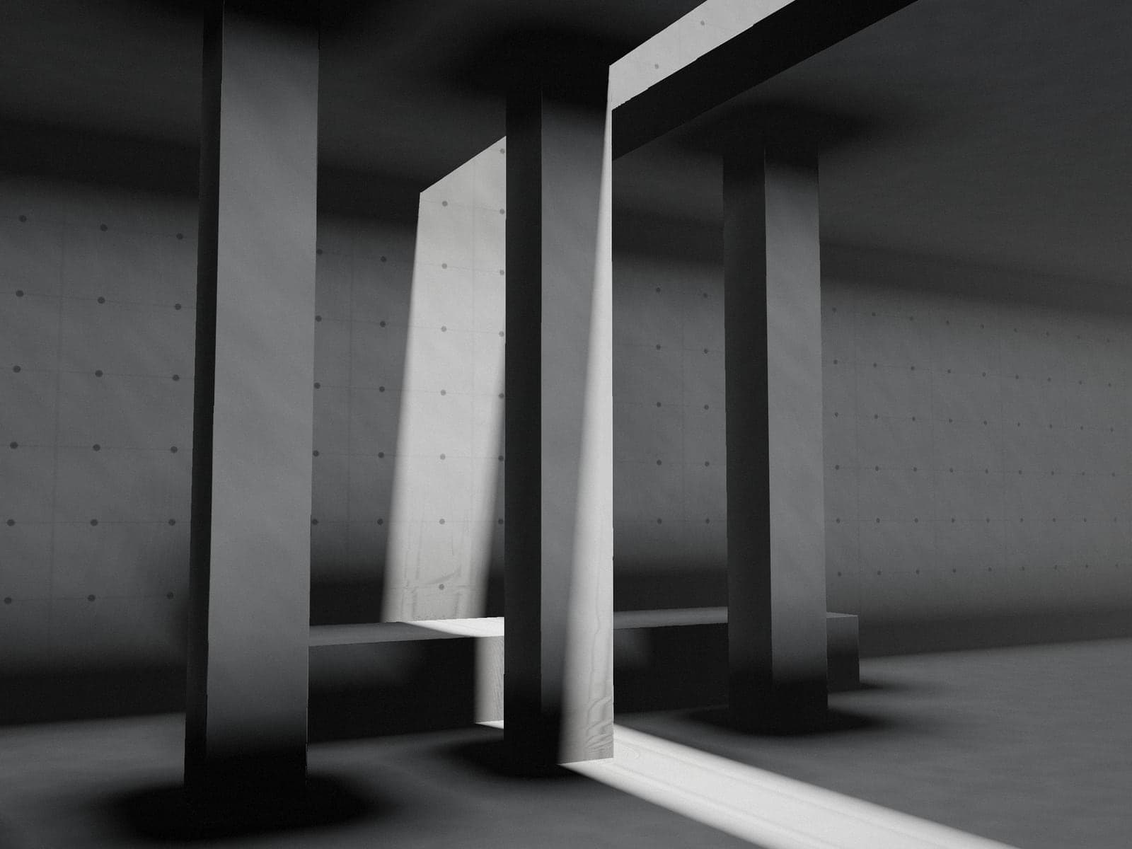 Concrete columns cut by a single beam of sunlight